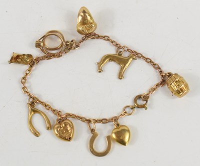 Lot 116 - A 9ct gold charm bracelet, with ten charms...