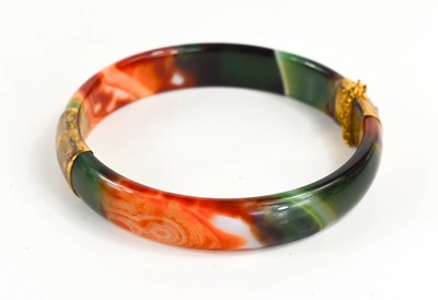 Lot 162 - A 14ct gold and glass bangle, in green, white...