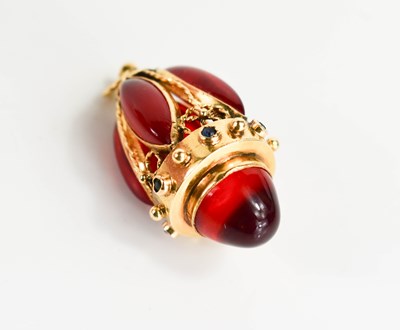 Lot 3 - A gold egg form pendant, set with red gemstone...