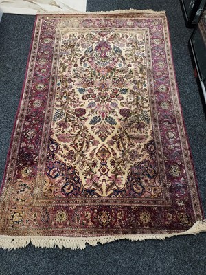 Lot 259 - A Persian silk and wool rug, with deep red...