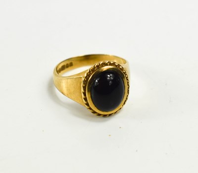 Lot 60 - A 9ct gold ring set with an oval dark cabochon...