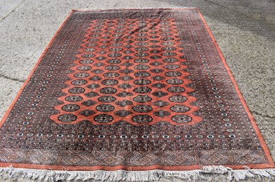 Lot 456 - A red ground wool rug, with geometric central...