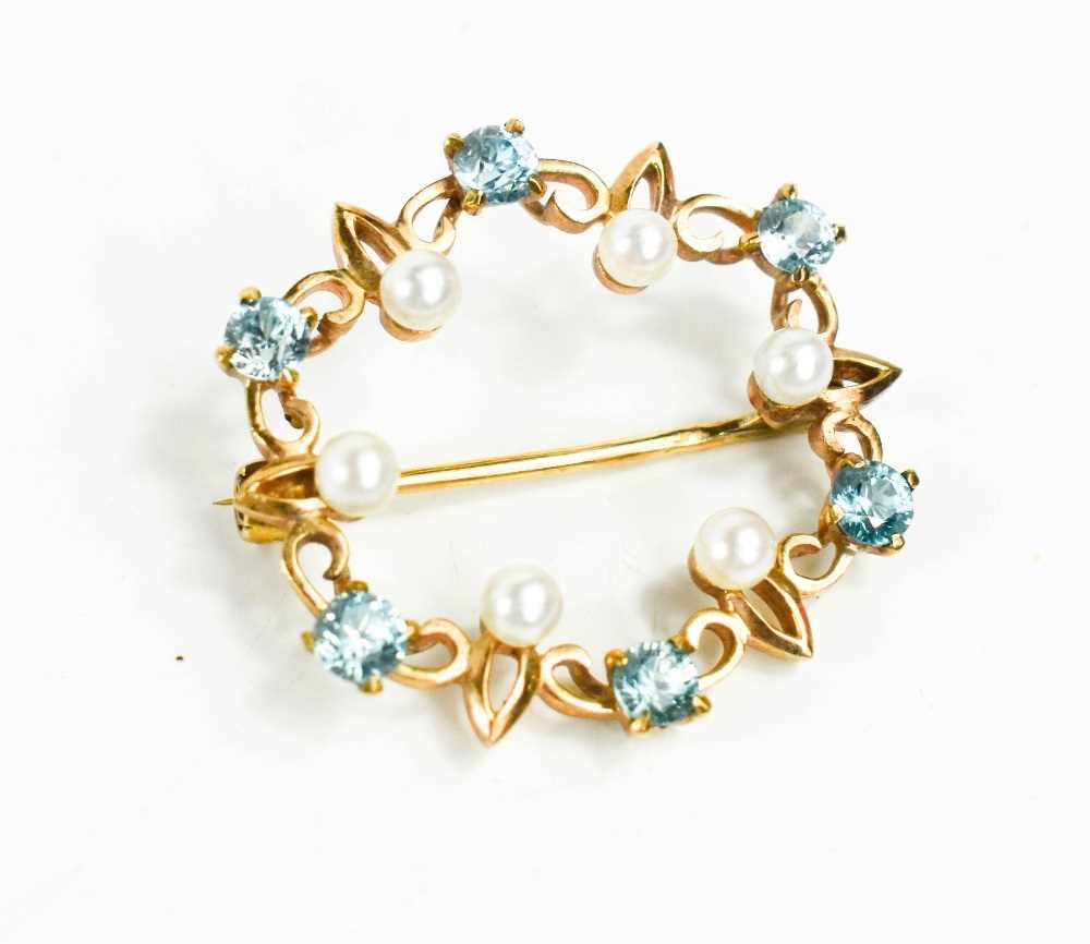 Lot 16 - A 9ct gold, pearl and blue topaz set circular...