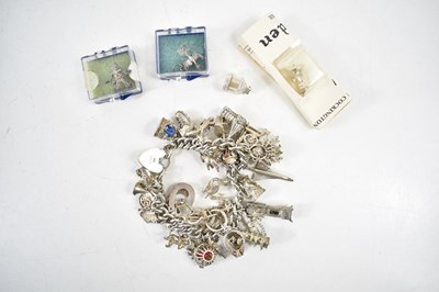 Lot 189 - A silver charm bracelet set with thirty five...