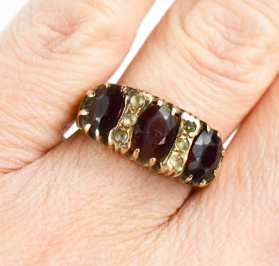 Lot 92 - A 9ct gold and garnet three stone ring, each...