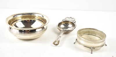 Lot 370 - A group of silver to include a tea strainer,...