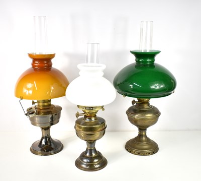 Lot 472 - A group of three paraffin lamps, the largest...