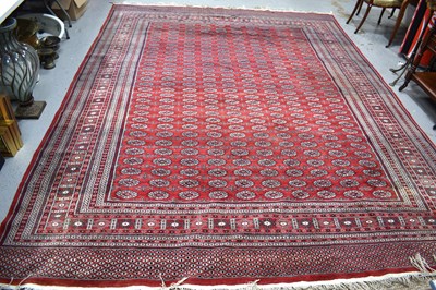 Lot 502 - A large wool rug, red ground, with geometric...