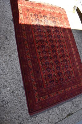 Lot 504 - A Middle eastern red ground rug decorated with...