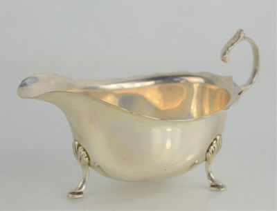 Lot 258 - A silver sauce boat, scroll handle and raised...