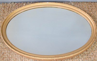 Lot 431 - An oval wall mirror with beaded edge, and...