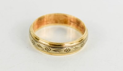 Lot 67 - A 9ct gold wedding band, with foliate engraved...