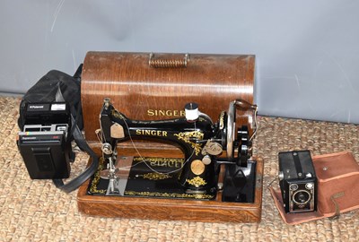 Lot 334 - A antique Singer sewing machine with oak case...