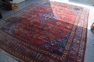 Lot 482 - A large Persian rug, red ground with...