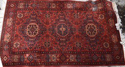 Lot 435 - A Middle Eastern rug with a red ground, three...