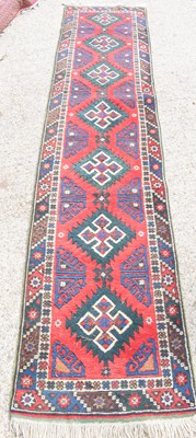 Lot 436 - A Middle Eastern runner with vibrant red...