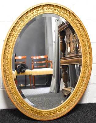 Lot 335 - A large oval giltwood mirror, the moulded...