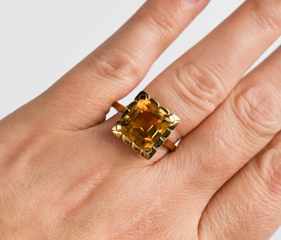 Lot 19 - A 9ct gold and emerald cut citrine dress ring,...