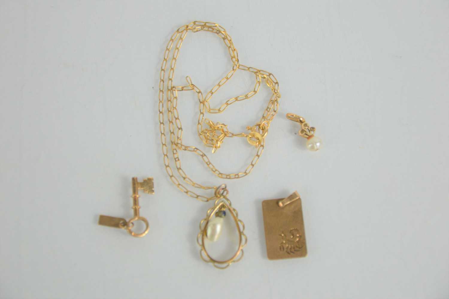 Lot 125 - A 9ct gold necklace and pendant, a 9ct key...