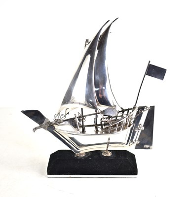 Lot 10 - A sterling silver model of a sailing boat on a...