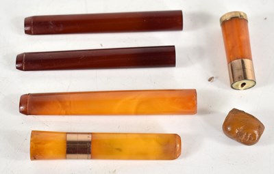 Lot 278 - A group of amber cigarette holders, two having...