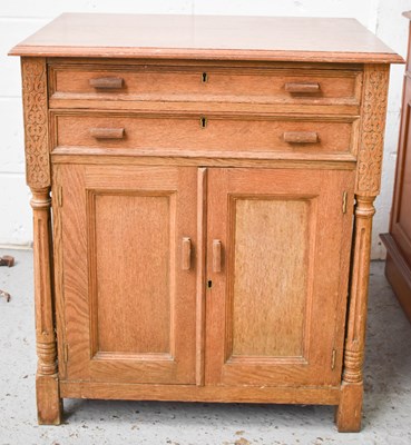 Lot 457 - A Mid-Century oak cupboard with two drawers...