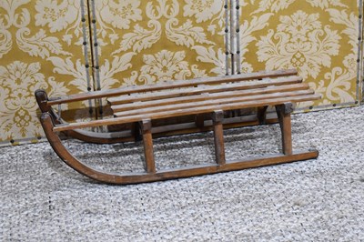 Lot 380 - A vintage wooden sledge, with metal straps to...