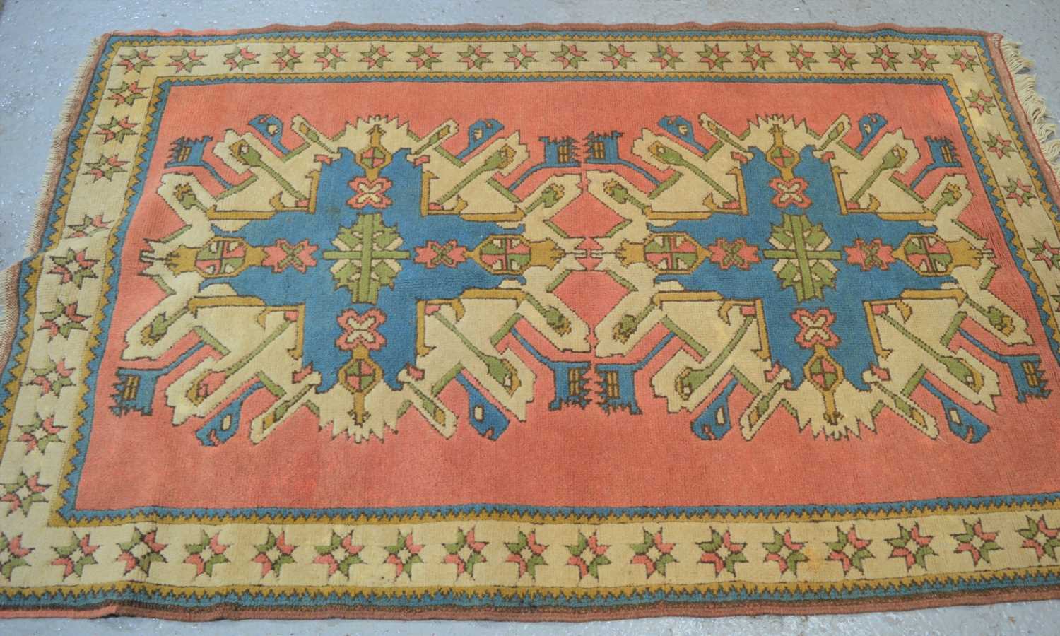 Lot 476 - A Middle Eastern wool rug with peach ground...