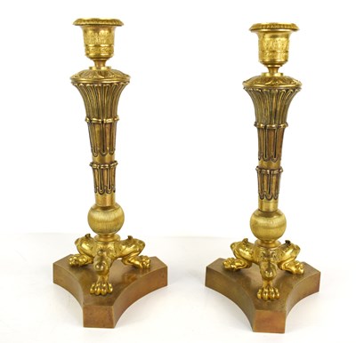 Lot 110 - A pair of Empire style gilt brass candlesticks,...