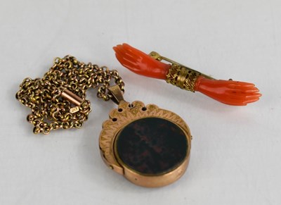 Lot 110 - A coral brooch in the form of two hands,...