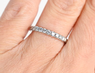 Lot 143 - A platinum and diamond half hoop eternity ring,...