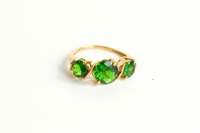 Lot 215 - A 9ct gold and green gemset three stone ring,...