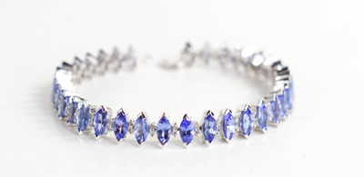 Lot 233 - A 9ct white gold and tanzanite tennis bracelet,...