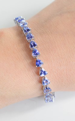 Lot 234 - A 9ct white gold and tanzanite tennis bracelet,...