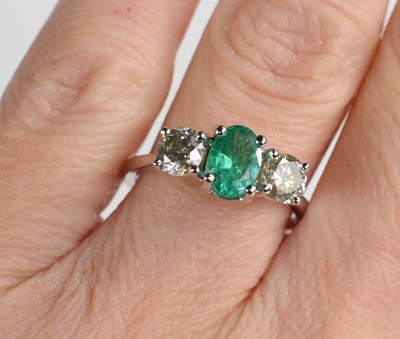 Lot 284 - An 18ct white gold emerald and diamond trilogy...