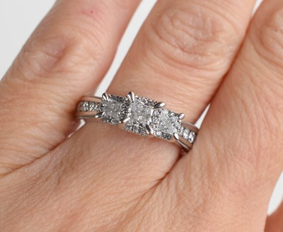 Lot 303 - A 14ct white gold trilogy ring set with...