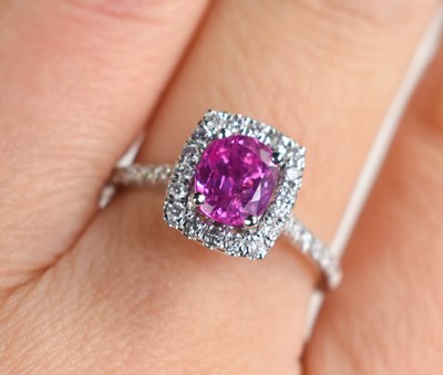 Lot 305 - A platinum ring set with an oval pink sapphire...