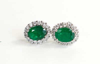 Lot 324 - A pair of 18ct white gold oval emerald and...