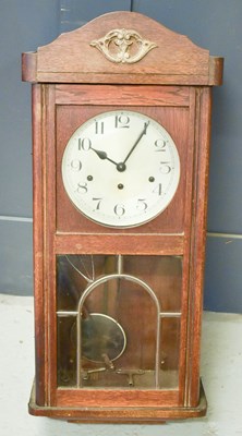 Lot 256 - A 1960s oak wall clock.