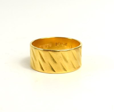 Lot 229 - A 22ct gold wedding band with textured design,...