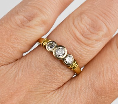 Lot 4 - An 18ct gold and diamond ring, the three...