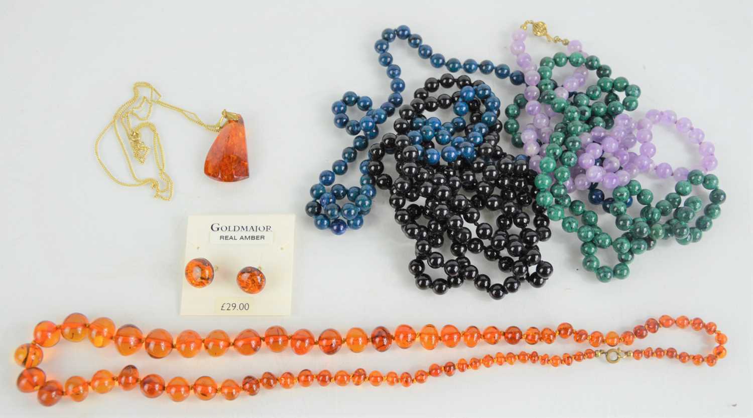 Lot 239 - An Amber beaded necklace, an amber pendant...