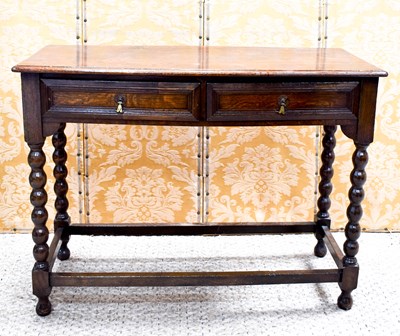 Lot 565 - A two drawer oak side table, with tall bobbin...