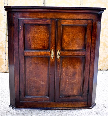 Lot 561 - An early 19th century oak corner cupboard with...