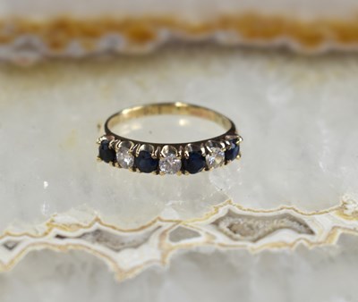 Lot 126 - A 9ct gold, diamond and sapphire half eternity...