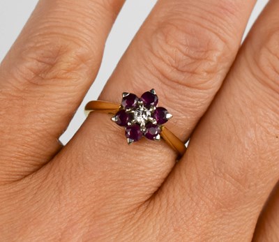 Lot 396 - An 18ct gold, ruby and diamond flowerhead ring,...