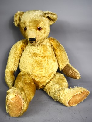 Lot 208 - A vintage golden plush teddy bear with glass...