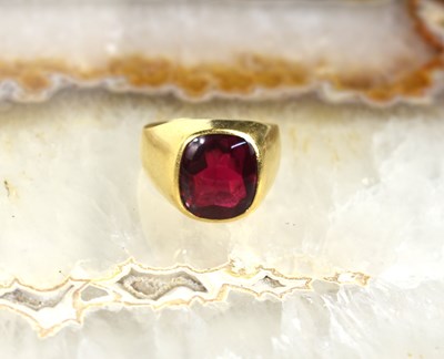 Lot 113 - An 18ct gold and ruby ring, size V/U, 10g.