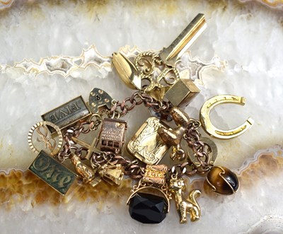 Lot 155 - A 9ct gold charm bracelet consisting of twenty...