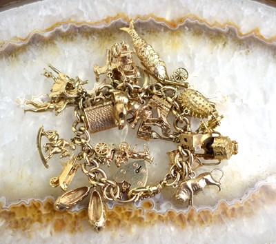 Lot 174 - A 9ct gold charm bracelet consisting of twenty...